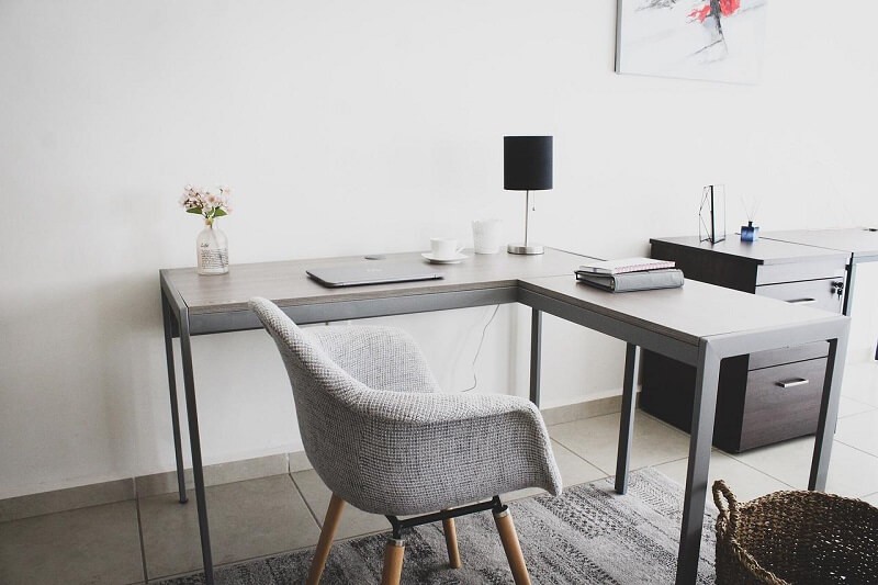 Grey, L-shaped desk that comes out into the room