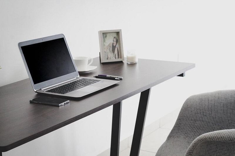 A slim desk with a laptop on