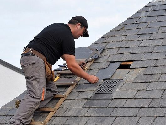 Roofer replacing a loose tile