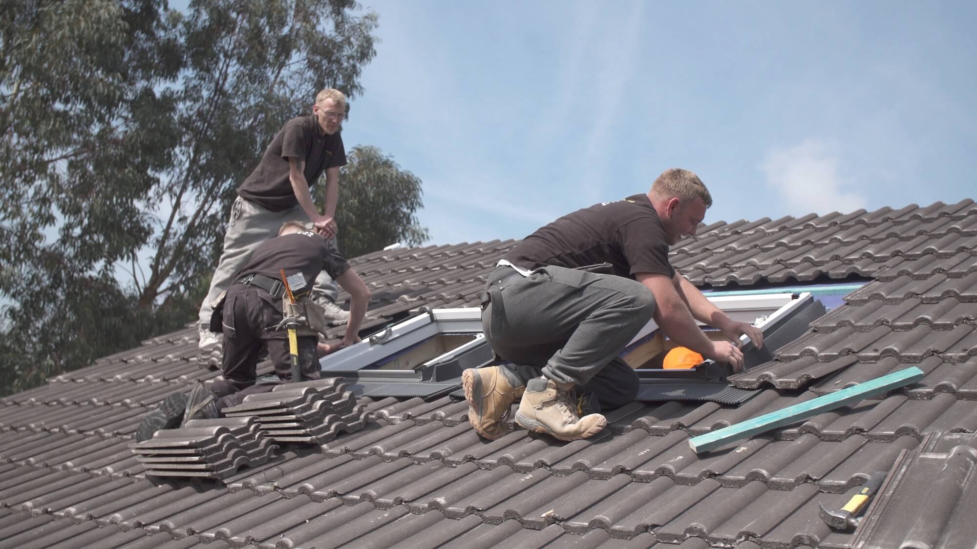 Three roofers installing a double roof window