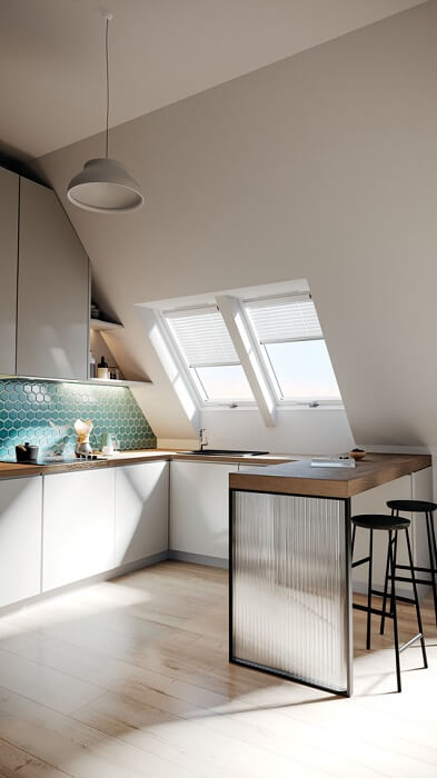 A kitchenette positioned under two side by side roof windows