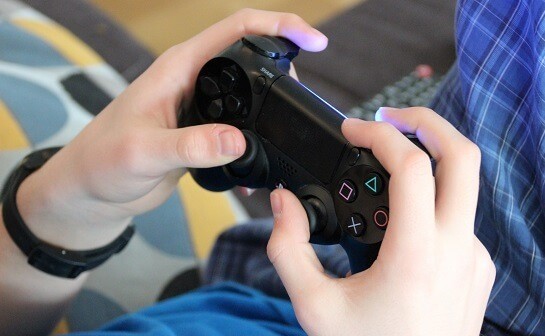 A close up of someone using a play station controller