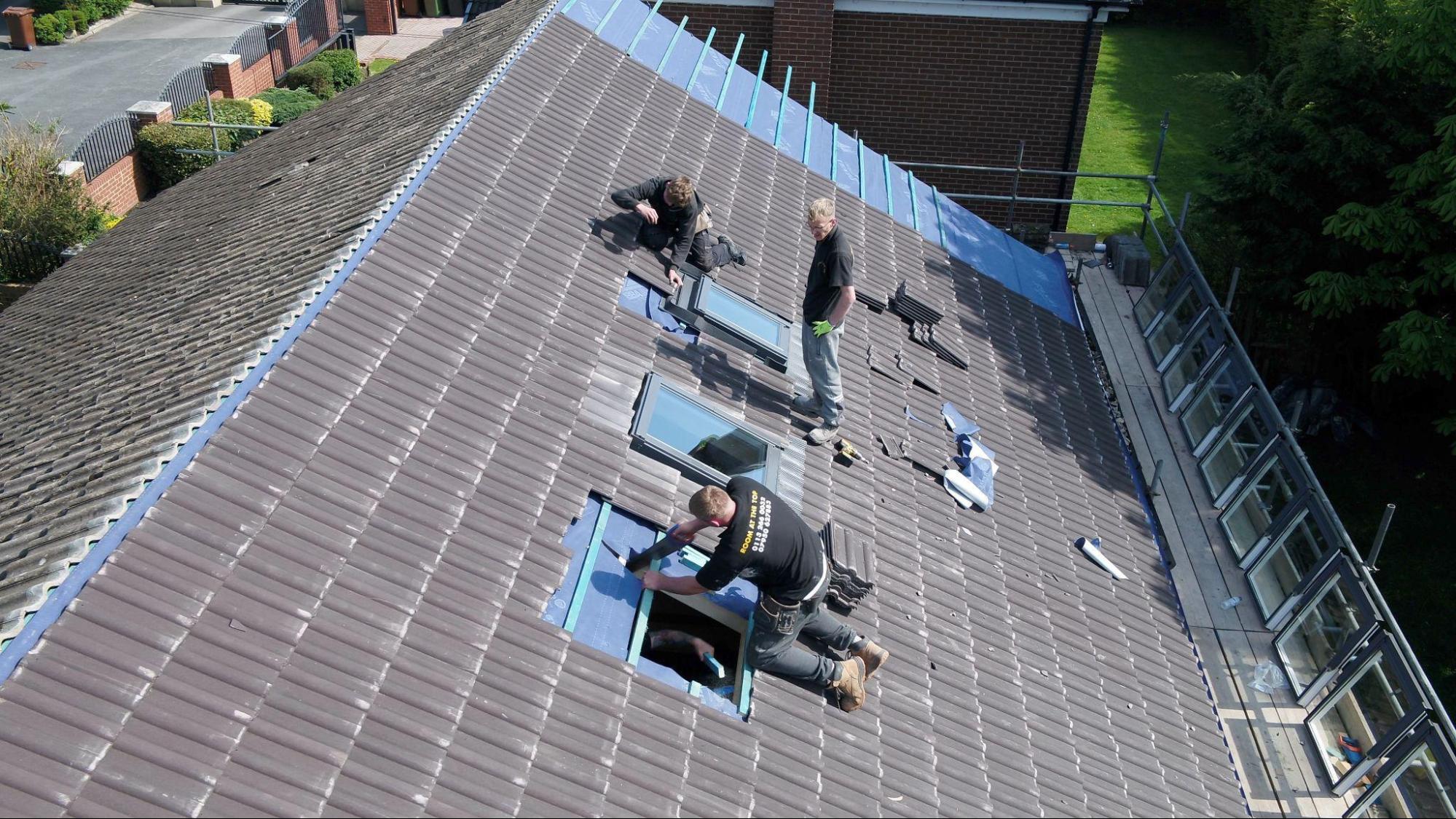 3 men on top of a roof installing 3 roof windows