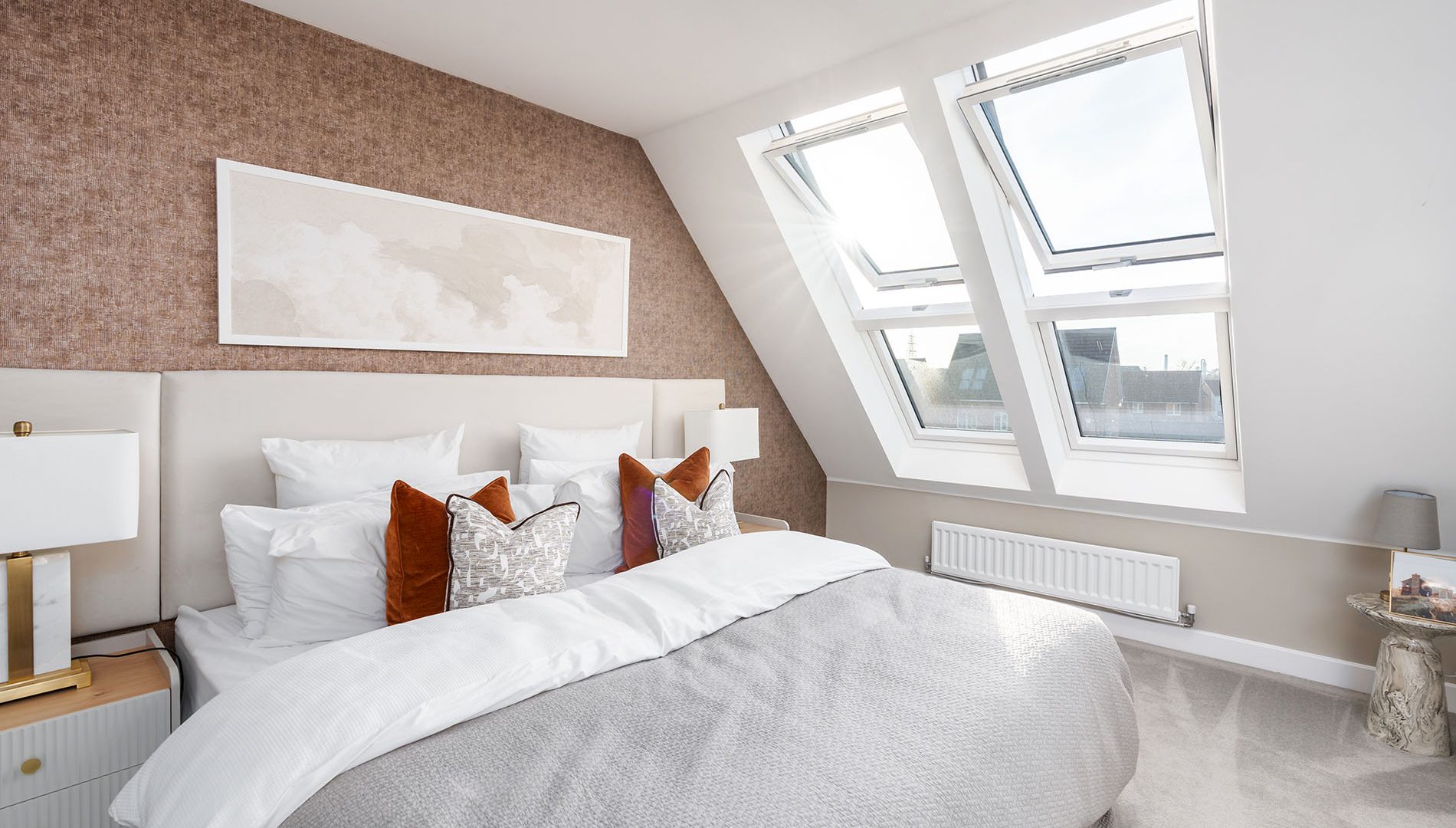 Neutrally designed bedroom with natural light flooding the area from two pitched roof lights